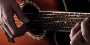 Musician playing on acoustic guitar